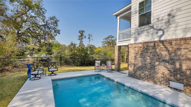 view of pool with a patio area and a yard