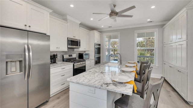 kitchen featuring light stone countertops, stainless steel appliances, white cabinetry, and sink