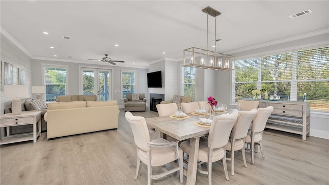 dining room with ceiling fan, ornamental molding, and light wood-type flooring