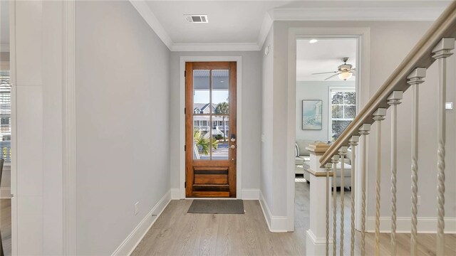 foyer featuring crown molding, ceiling fan, and light wood-type flooring