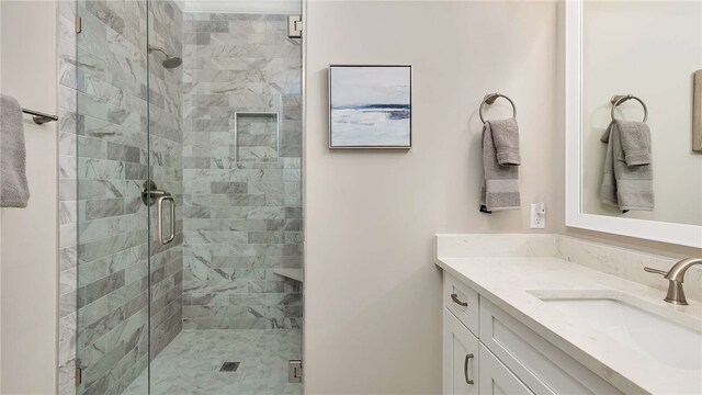 bathroom with vanity and a shower with shower door