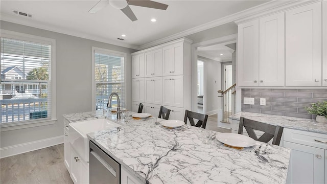 kitchen featuring dishwasher, backsplash, white cabinets, and a breakfast bar area