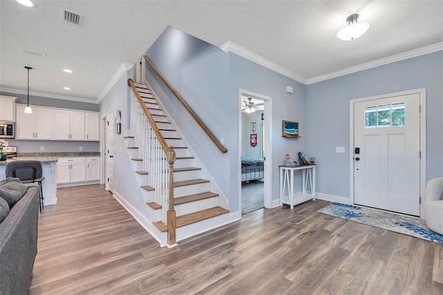69 Allie Loop, Brunswick, GA 31525 - foyer with ornamental molding, light wood-style floors, stairway, ceiling fan, and a textured ceiling