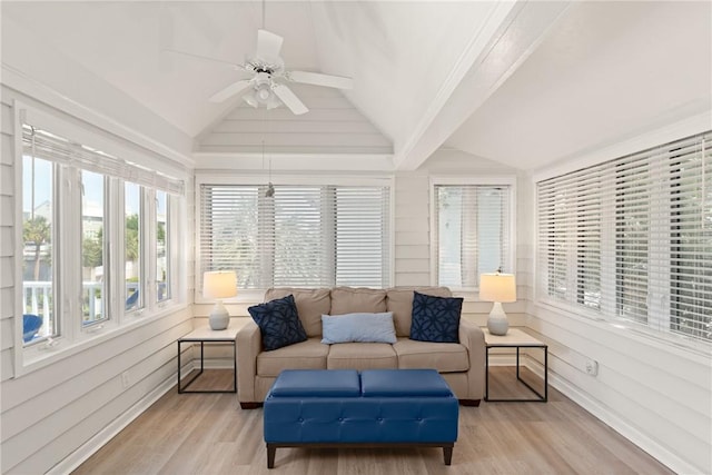 sunroom featuring a wooden deck, wood finished floors, and lofted ceiling