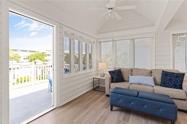 sunroom / solarium featuring plenty of natural light, wood finished floors, and lofted ceiling