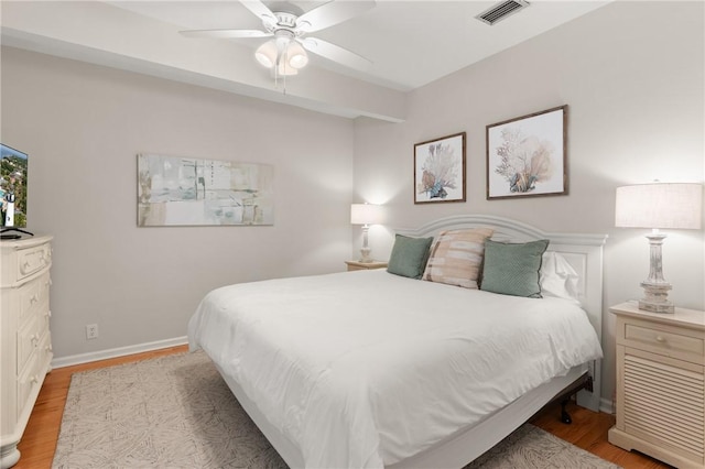 bedroom with visible vents, a ceiling fan, baseboards, and light wood-type flooring