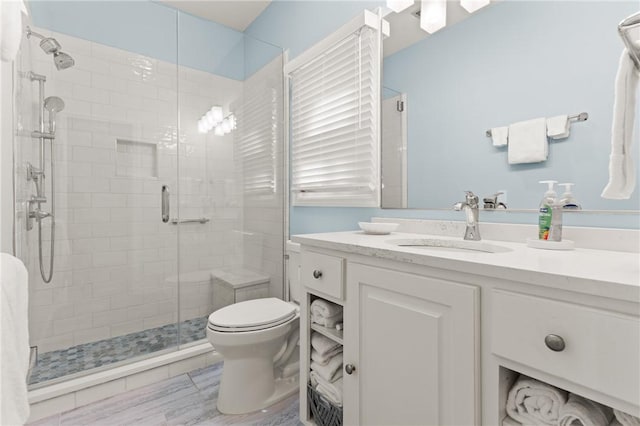 full bath featuring vanity, a shower stall, and toilet