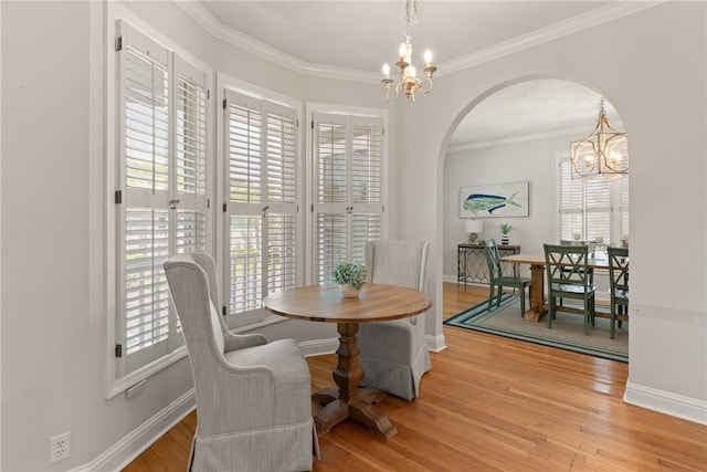 dining area with arched walkways, a wealth of natural light, and a chandelier