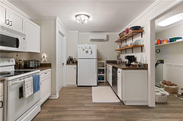 kitchen with ornamental molding, dark countertops, white appliances, a wall mounted AC, and a sink