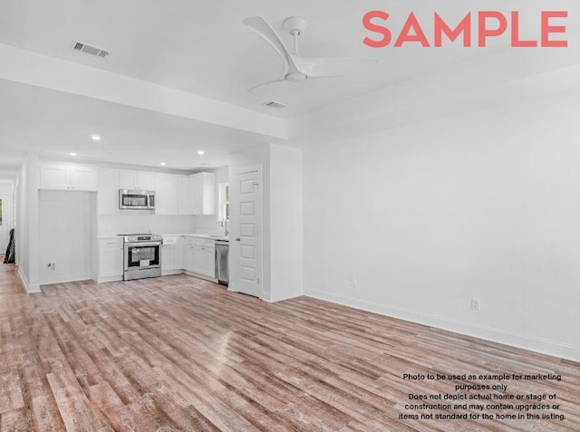 unfurnished living room featuring ceiling fan and light wood-type flooring