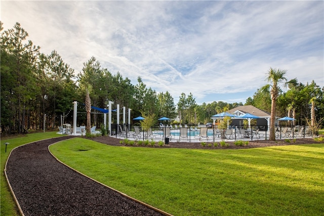 view of community featuring a lawn and a swimming pool