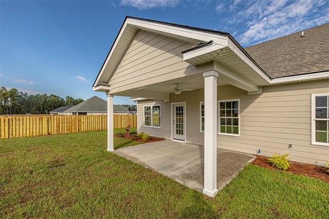 back of property featuring a lawn, a patio area, and ceiling fan