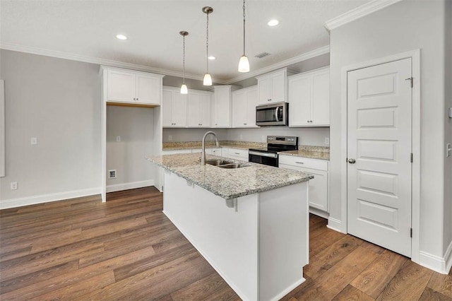 kitchen featuring a center island with sink, sink, appliances with stainless steel finishes, light stone counters, and white cabinetry