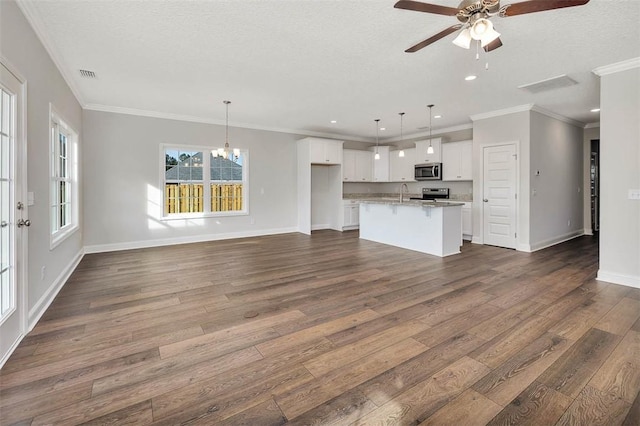 unfurnished living room with dark hardwood / wood-style flooring, ceiling fan with notable chandelier, a textured ceiling, and ornamental molding