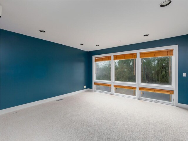 unfurnished room with baseboards, visible vents, and carpet flooring