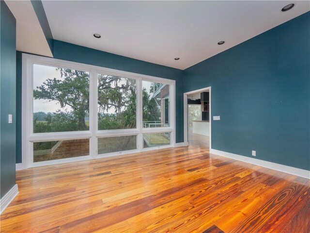 spare room with hardwood / wood-style flooring, baseboards, and recessed lighting