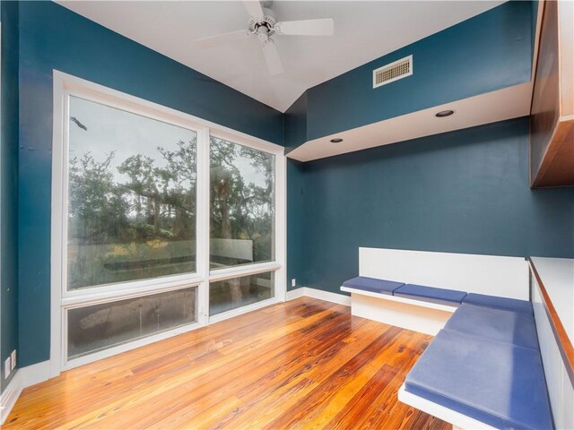 unfurnished room with baseboards, visible vents, wood finished floors, and a ceiling fan