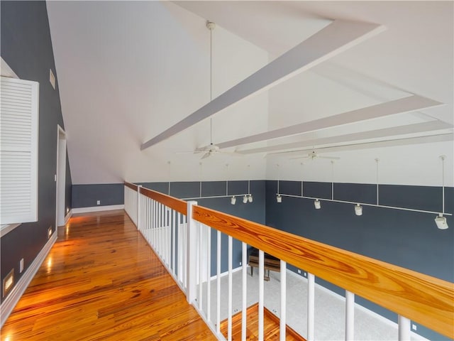 corridor featuring baseboards, high vaulted ceiling, wood finished floors, and beamed ceiling