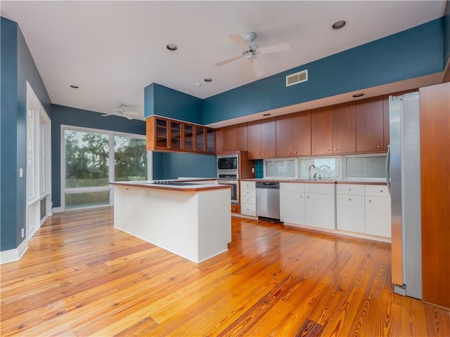 kitchen featuring visible vents, ceiling fan, a sink, and stainless steel appliances