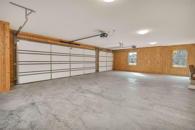 garage with a garage door opener and wood walls