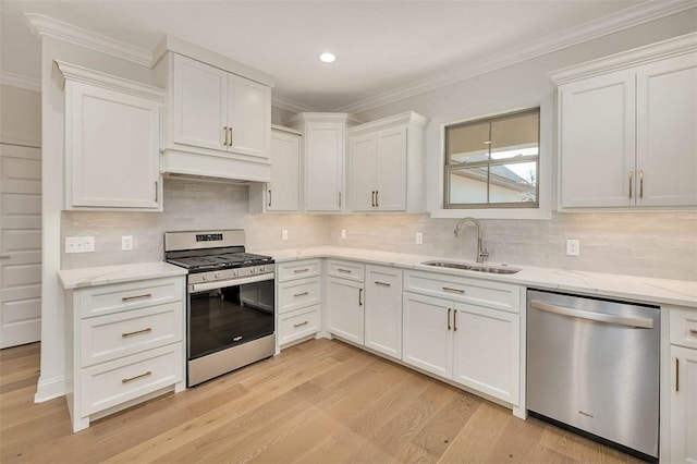 kitchen with sink, crown molding, stainless steel appliances, light hardwood / wood-style floors, and white cabinets