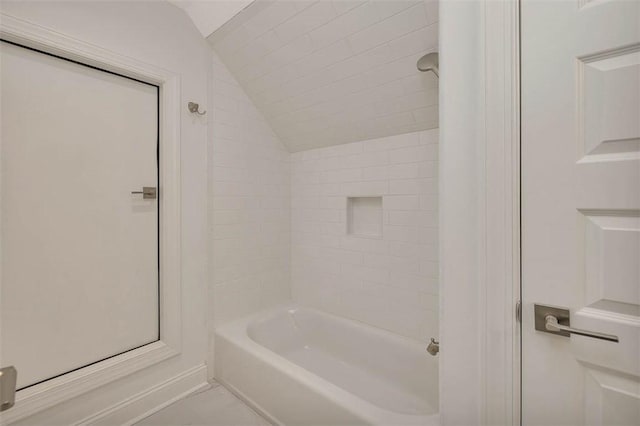 bathroom with tiled shower / bath and vaulted ceiling