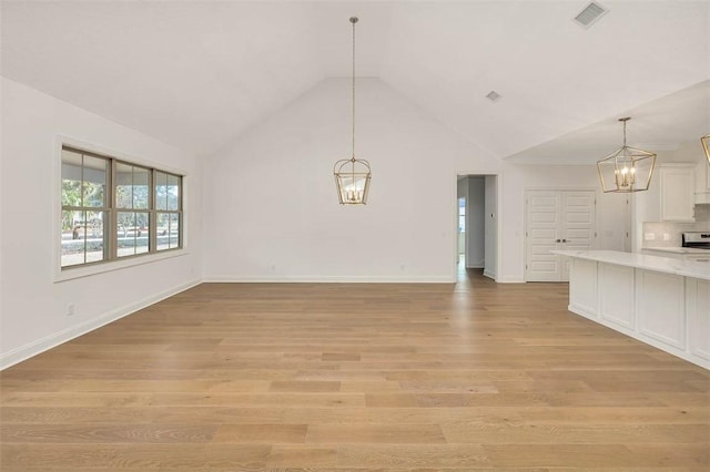 unfurnished living room with a chandelier, high vaulted ceiling, and light hardwood / wood-style flooring