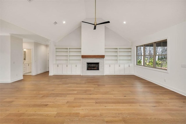 unfurnished living room featuring built in shelves, high vaulted ceiling, and light hardwood / wood-style floors