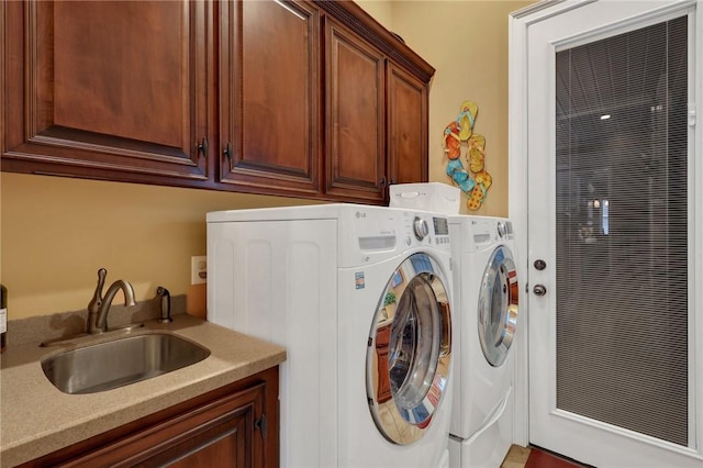 washroom with cabinet space, independent washer and dryer, and a sink