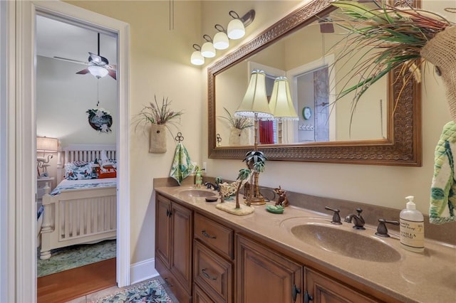 bathroom with ceiling fan, ensuite bath, double vanity, and a sink