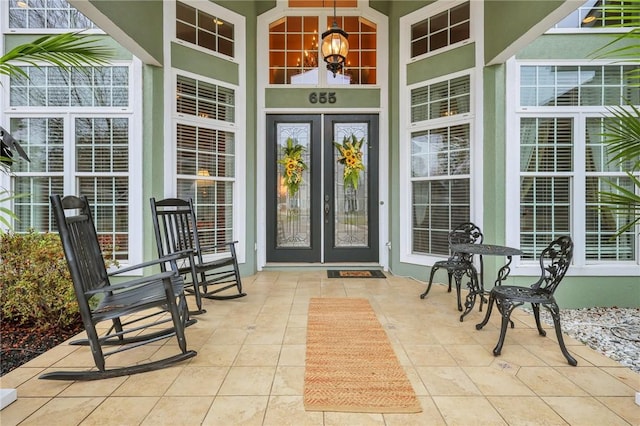 entrance to property featuring covered porch and stucco siding