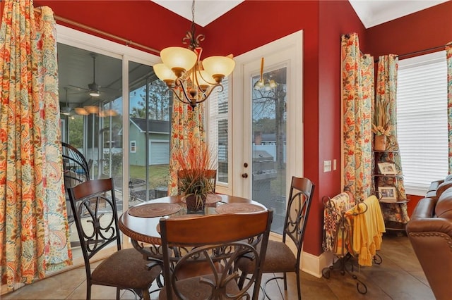 dining area featuring tile patterned floors, ceiling fan with notable chandelier, and baseboards