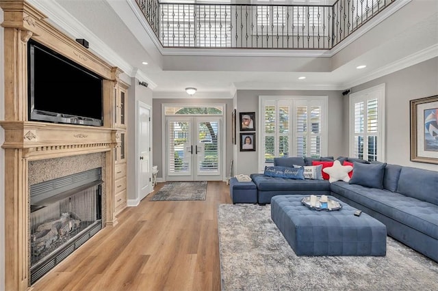 living room featuring ornamental molding, a healthy amount of sunlight, and a high ceiling