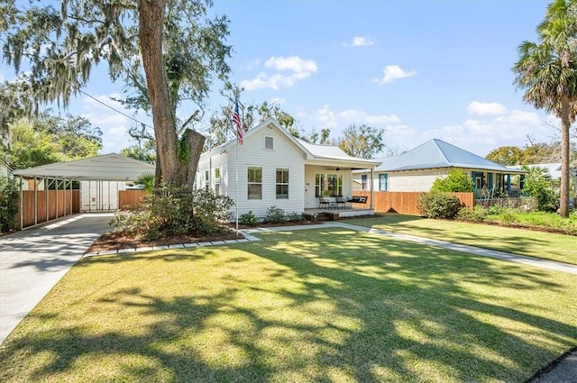 view of front of property featuring a detached carport, a front yard, fence, and driveway