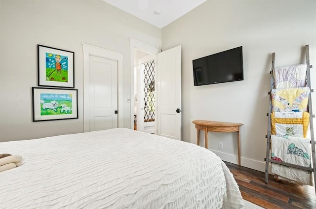 bedroom with baseboards and dark wood finished floors