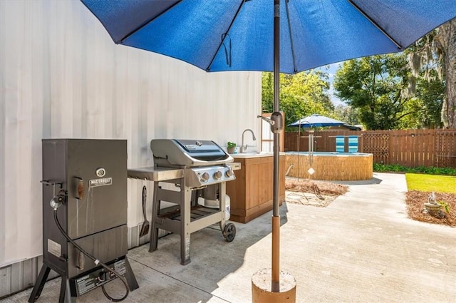 view of patio with area for grilling and fence