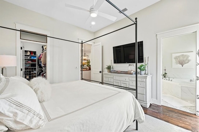 bedroom with wood finished floors, visible vents, a spacious closet, a closet, and ensuite bathroom