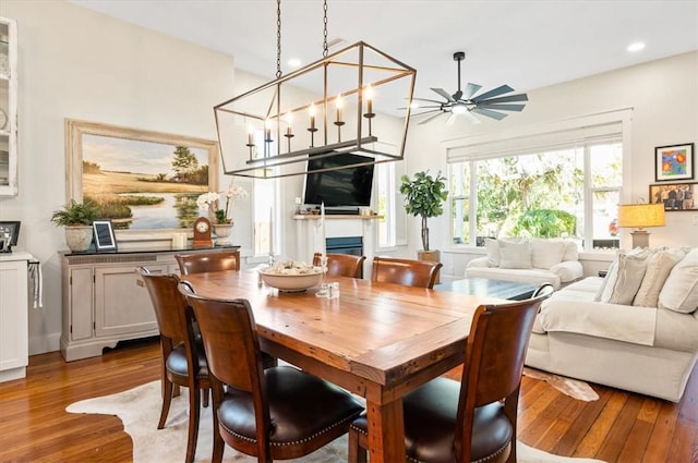 dining space featuring ceiling fan, recessed lighting, wood finished floors, and a fireplace