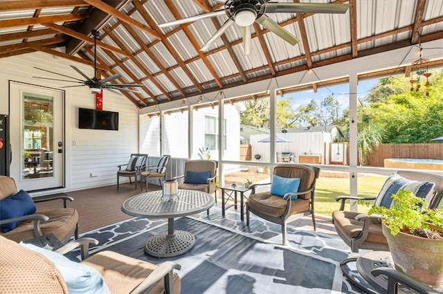 sunroom / solarium featuring a ceiling fan and vaulted ceiling