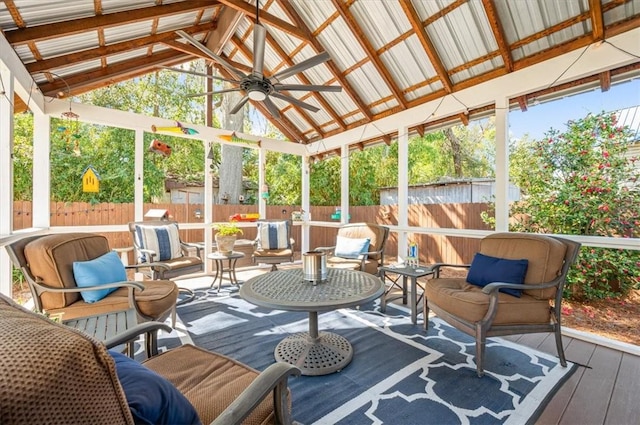 sunroom featuring lofted ceiling and a ceiling fan