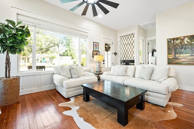 living area with plenty of natural light, baseboards, and hardwood / wood-style floors