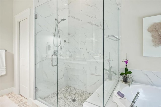 bathroom with a garden tub and a marble finish shower