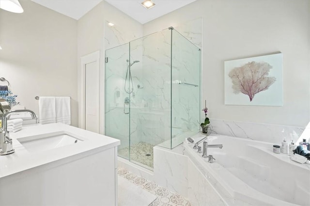 bathroom with a marble finish shower, vanity, and a whirlpool tub