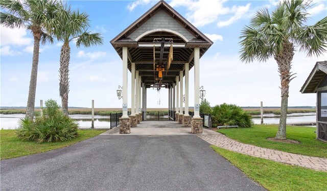 view of home's community with a water view and a yard