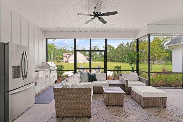 sunroom featuring a ceiling fan, an outdoor living space, and area for grilling