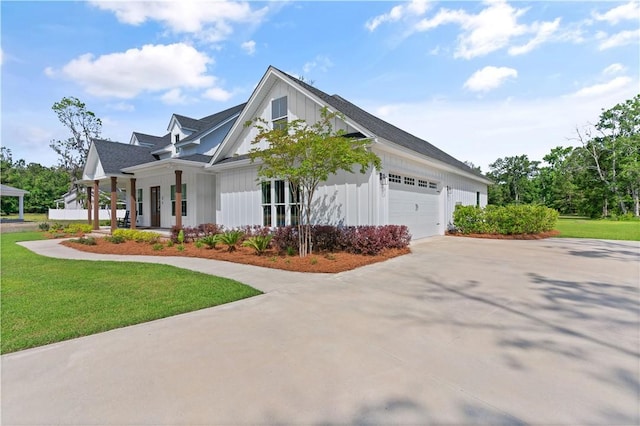 view of front facade featuring concrete driveway, a garage, a front yard, board and batten siding, and covered porch