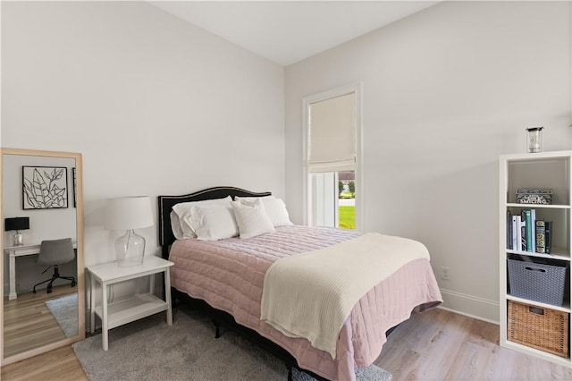 bedroom with wood finished floors, baseboards, and a desk