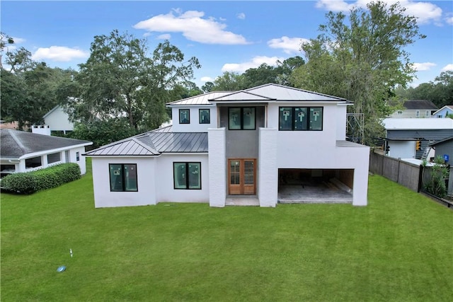 rear view of property featuring a lawn