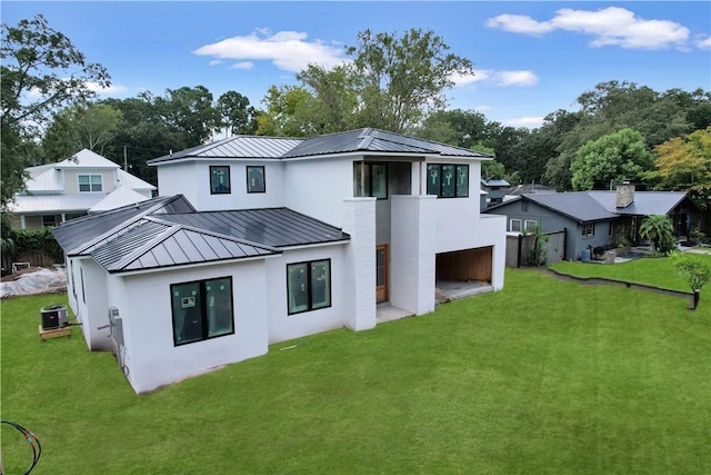 rear view of house with a lawn and central AC unit