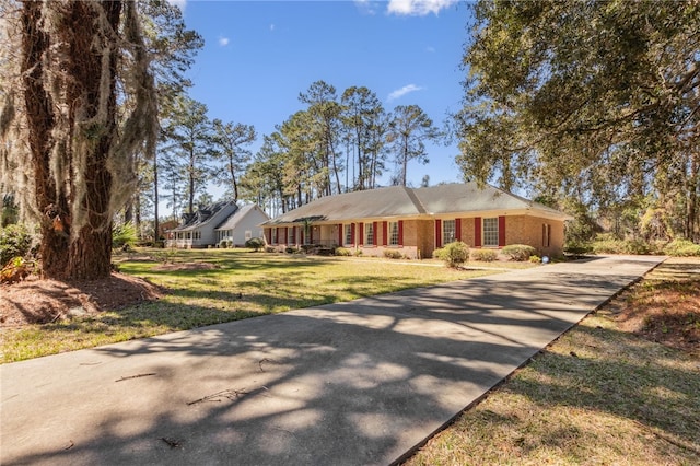 ranch-style home featuring driveway and a front yard